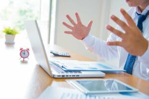 Comment savoir quand changer son disque dur ? Jeune homme qui se retrouve devant son PC qui bloque.